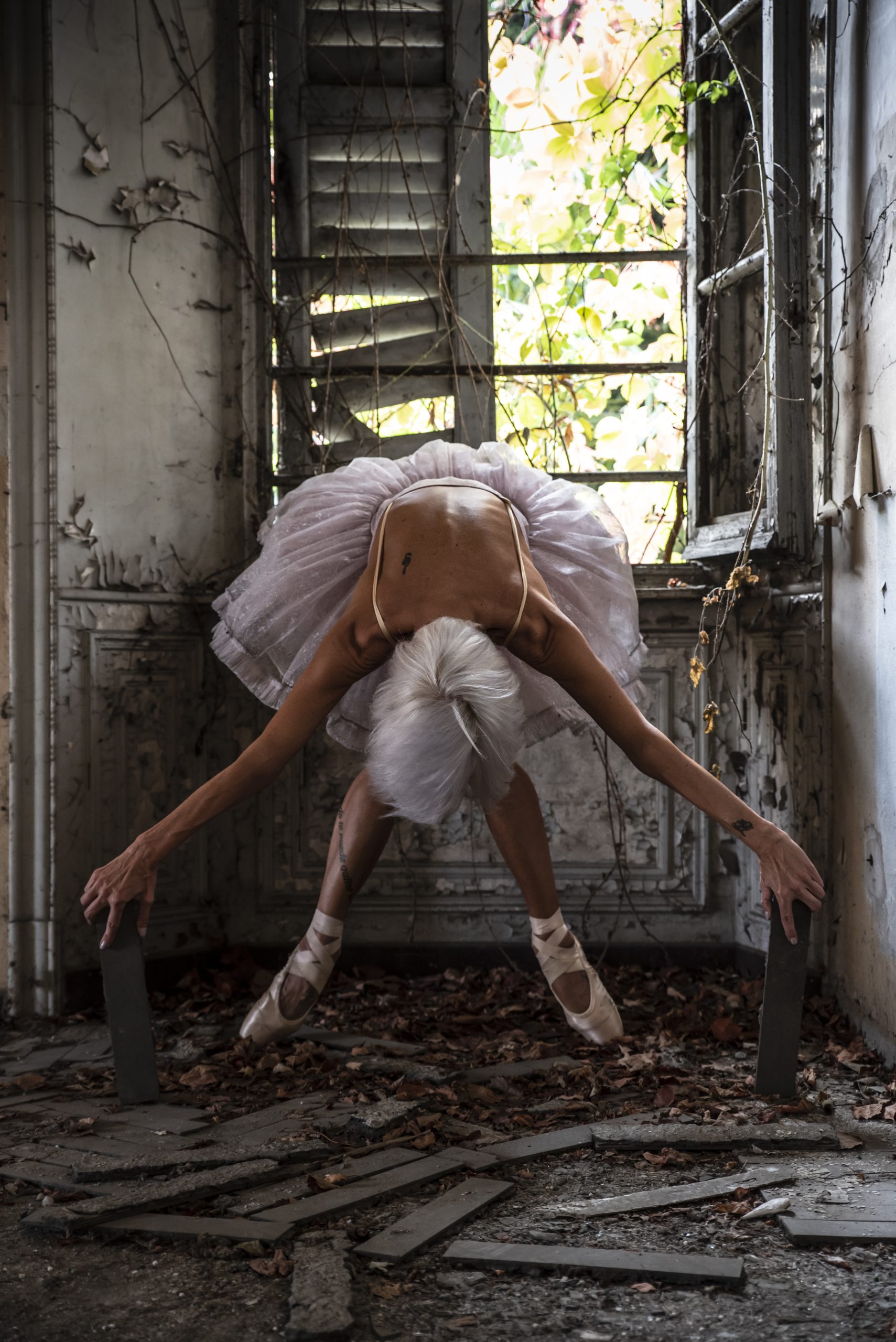 L'inchino di una ballerina in tutù in una casa abbandonata