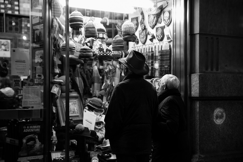 Milano: due anziani guardano una vetrina