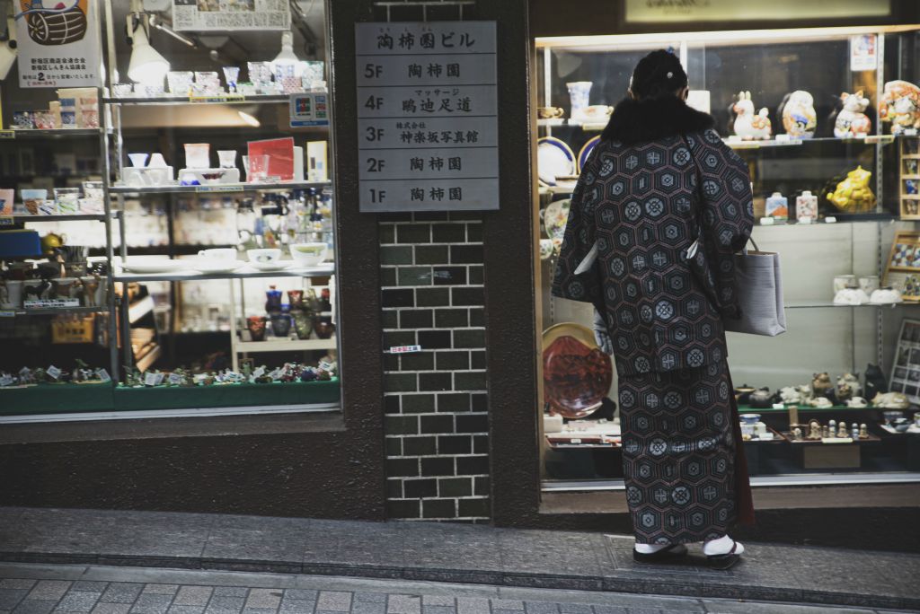 Japan Streets: una signora osserva una vetrina di un negozio di souvenir