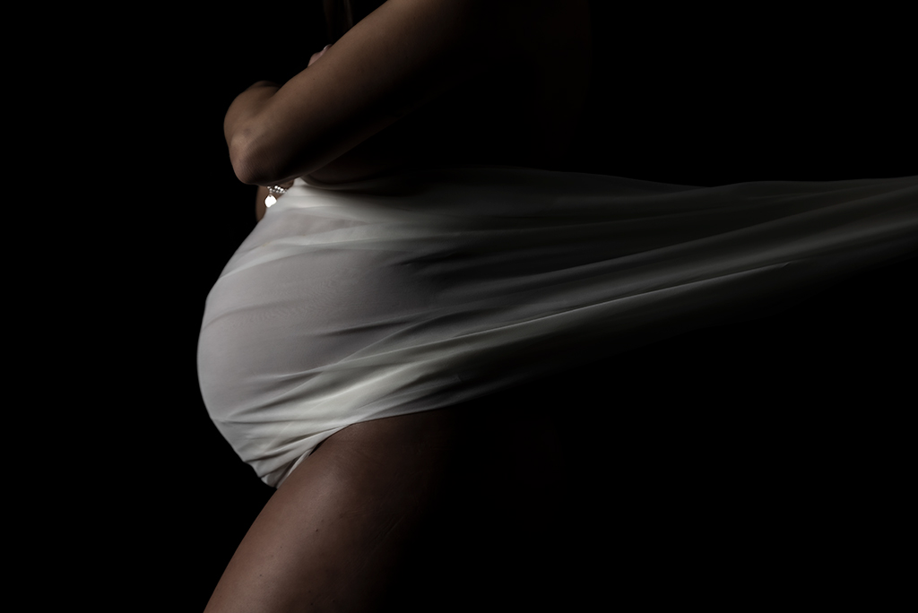 una donna incinta avvolta in telo bianco